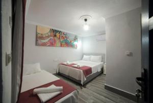 AhmetçeAssos Yalı Butik Otel Beach的一间设有两张床的客房,墙上挂着一幅画
