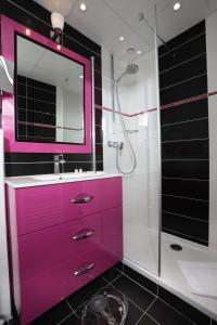 里昂塞尔斯丁酒店的粉红色的浴室设有水槽和淋浴