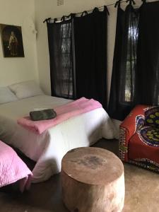 KwekweNyangombe Backpackers的一间设有床铺和桌子的房间