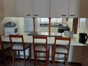 圣卢西亚Turtleshaven的厨房配有三把椅子和台面