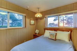 卡农海滩Tolovana Treasure的一间卧室设有一张床和两个窗户。