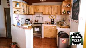 瓦拉斯Kame House hostel的厨房配有木制橱柜和冰箱。