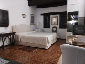 Taverne莫托德尔加洛旅馆的卧室配有白色的床和电视。