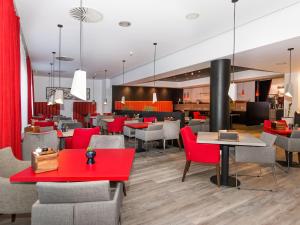 格拉特布鲁格DORMERO Hotel Zürich Airport的一间设有红色桌椅的用餐室