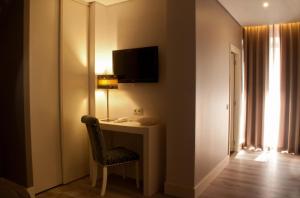 法鲁利雅精品水族酒店的客房配有带台灯和椅子的书桌