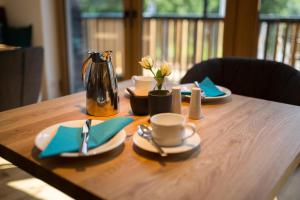 克罗夫Rieslingquartier - Mosel Wein Hotel的一张木桌,上面有盘子和茶壶