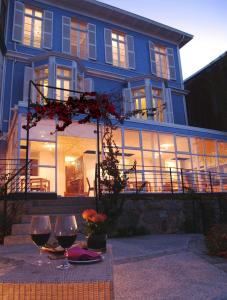 瓦尔帕莱索泽罗酒店的蓝色房子,带两杯葡萄酒