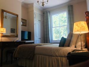 梅登黑德Norfolk House的一间卧室配有一张床、一个窗口和一张书桌