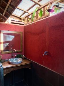 巴芝丹Harry's Ocean House Pacitan的红色的浴室设有水槽和镜子