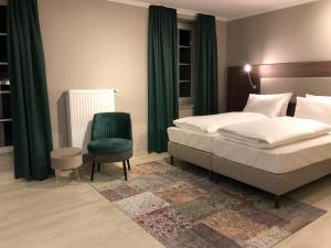 不莱梅Arthotel ANA Liberty Bremen City的一间卧室配有一张床和一把绿色椅子