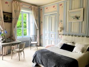 QuintinLes chambres d'hôtes du Manoir de Roz-Maria的一间卧室配有一张床、一张书桌和一个窗户。