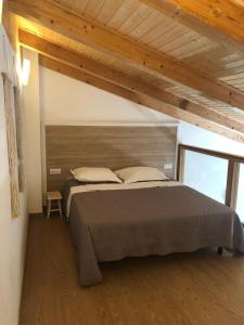 波尔图Résidence Porto Marine的一间带一张大床的卧室,位于一个拥有木制天花板的房间