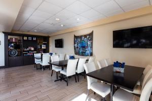 赛百灵SEVEN Sebring Raceway Hotel的用餐室配有黑桌和白色椅子