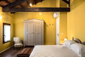 基亚拉诺卡西亚蓝旅馆的卧室设有白色的床和黄色的墙壁