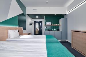 于韦斯屈莱GreenStar Hotel Jyväskylä的一间卧室设有一张大床和绿色的墙壁