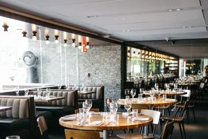 达拉斯陆梦酒店的餐厅设有木桌和椅子,拥有砖墙