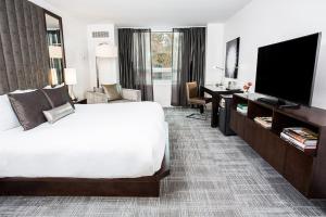 达拉斯陆梦酒店的配有一张床和一台平面电视的酒店客房