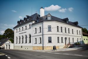 OsečnáHotel a Hostinec Slunce的黑色屋顶的白色大建筑