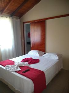 皮雷诺波利斯Pousada Bontempo的卧室配有一张大白色的红色床单
