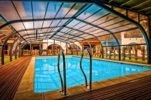 阿尔维厄Hôtel & Spa La Ferme de l'Izoard的一个带玻璃天花板的室内游泳池