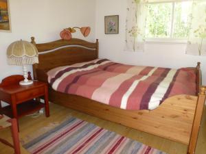 Ransäter普瑞斯特雷恩旅舍的一间卧室配有一张木床、一盏灯和一张桌子