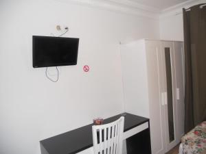 巴黎太平洋酒店 的客房设有书桌和墙上的电视。