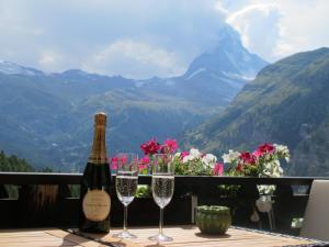 采尔马特Matterhorn Ried Suite的桌子上放有一瓶葡萄酒和两杯酒