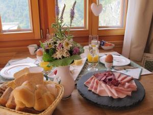 采尔马特Matterhorn Ried Suite的餐桌,桌上有面包和鸡蛋,还有一盘食物
