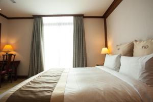 台北富园国际商务饭店的卧室配有一张大白色床和窗户