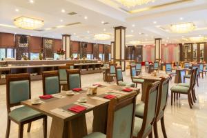 谅山Muong Thanh Luxury Lang Son Hotel的一间带木桌椅的餐厅和一间酒吧