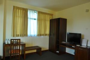 康提康提阿玛瑞天空酒店的一间配有电视和椅子的酒店客房和一间客房