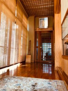 野沢Apartment at Toemu Nozawa的客房铺有木地板,设有一扇窗户门