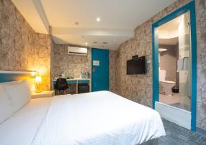 台北久居栈旅店的卧室配有一张白色大床和一张书桌