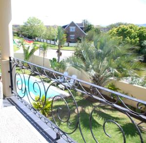 普利登堡湾曼德勒普利登堡湾酒店的享有游泳池和棕榈树景致的阳台