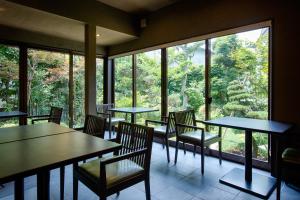 嬉野市吉田日式旅馆的餐厅设有桌椅和大窗户。