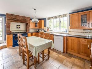 沃里克Pinley Hill House的厨房配有木制橱柜和桌椅