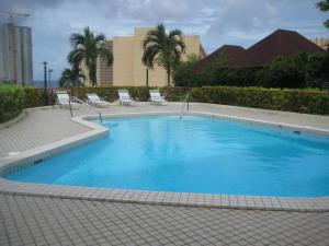 塔穆宁图蒙海湾船长酒店的一个带椅子和棕榈树的大型蓝色游泳池