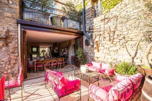 CarcassoneChambre et Gite Le Roc sur l'Orbieu的一个带粉红色桌椅和石墙的庭院
