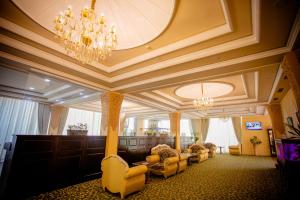 塔什干荣耀酒店的客厅配有椅子和吊灯。