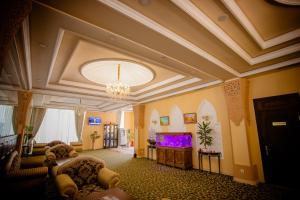 塔什干荣耀酒店的一个带吊灯和电视的大客厅