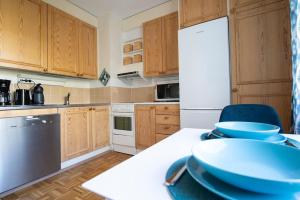 米凯利Mikkeli center apartment的厨房配有木制橱柜和白色冰箱。