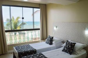 弗洛里亚诺波利斯Flat Pietra的酒店客房设有两张床和大窗户。