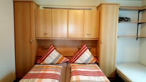 梅德巴赫维特布里克度假屋的一间带两张床和木柜的小卧室