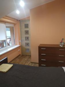 斯科列Садиба у Богдана的一间卧室配有一张床、一个梳妆台和一扇窗户。