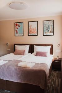 波兰尼卡-兹德鲁伊Villa Paula的卧室配有两张床,墙上有三幅画