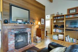 卡农海滩Chapman Cottage的客厅设有壁炉,上面配有电视