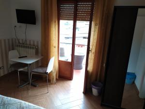 罗马卡萨蔚酒店的客房设有书桌、桌子和带窗户的门。
