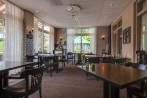HaarloHCR王子酒店的用餐室设有桌椅和窗户。