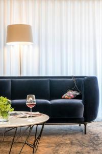 埃森敏特洛普斯布尔加腾多夫乡村酒店的客厅里一张蓝色的沙发,配有桌子