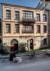 纳乌萨玛西亚斯Boutique Hotel Palea Poli的一座古老的砖砌建筑,前面有一辆自行车停放